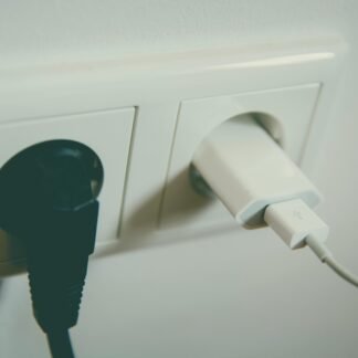A close-up view of a wall outlet with two plugs inserted, capturing the simplicity of electrical connectivity.
